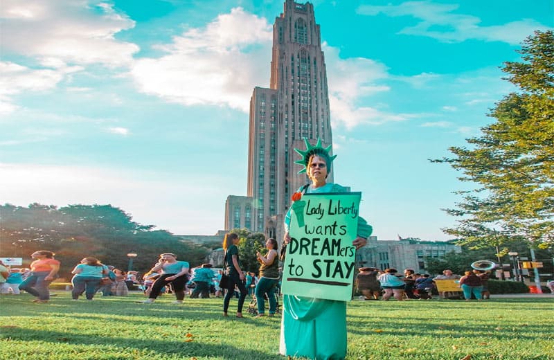 DACA unconstitutional: Woman Holding Flyer That Says, "Dreamers Want to Stay." Photo by Maria Oswalt on Unsplash